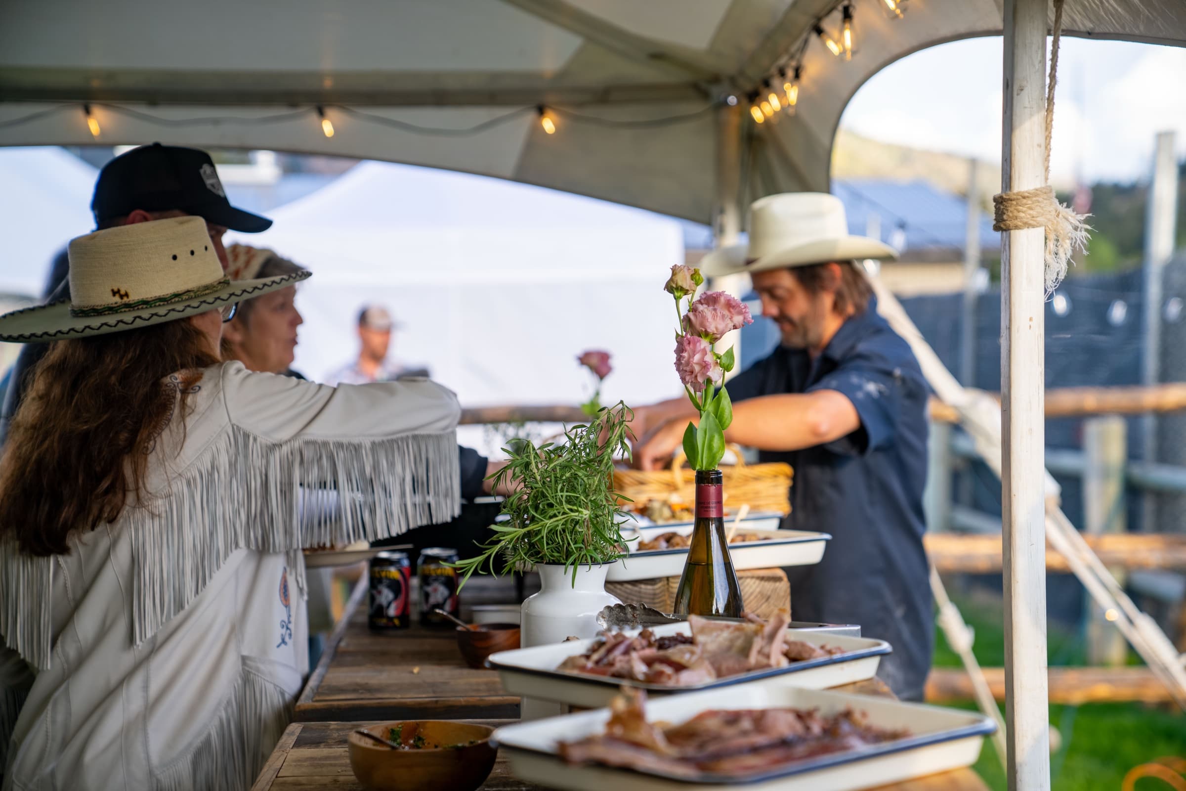 Guests being served at the long table under the tent
