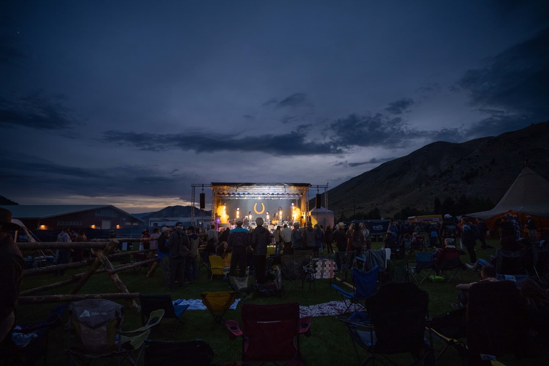 The Horseshoe stage lit at dusk on the valley floor, the crowd spread across the grass and dark mountains behind